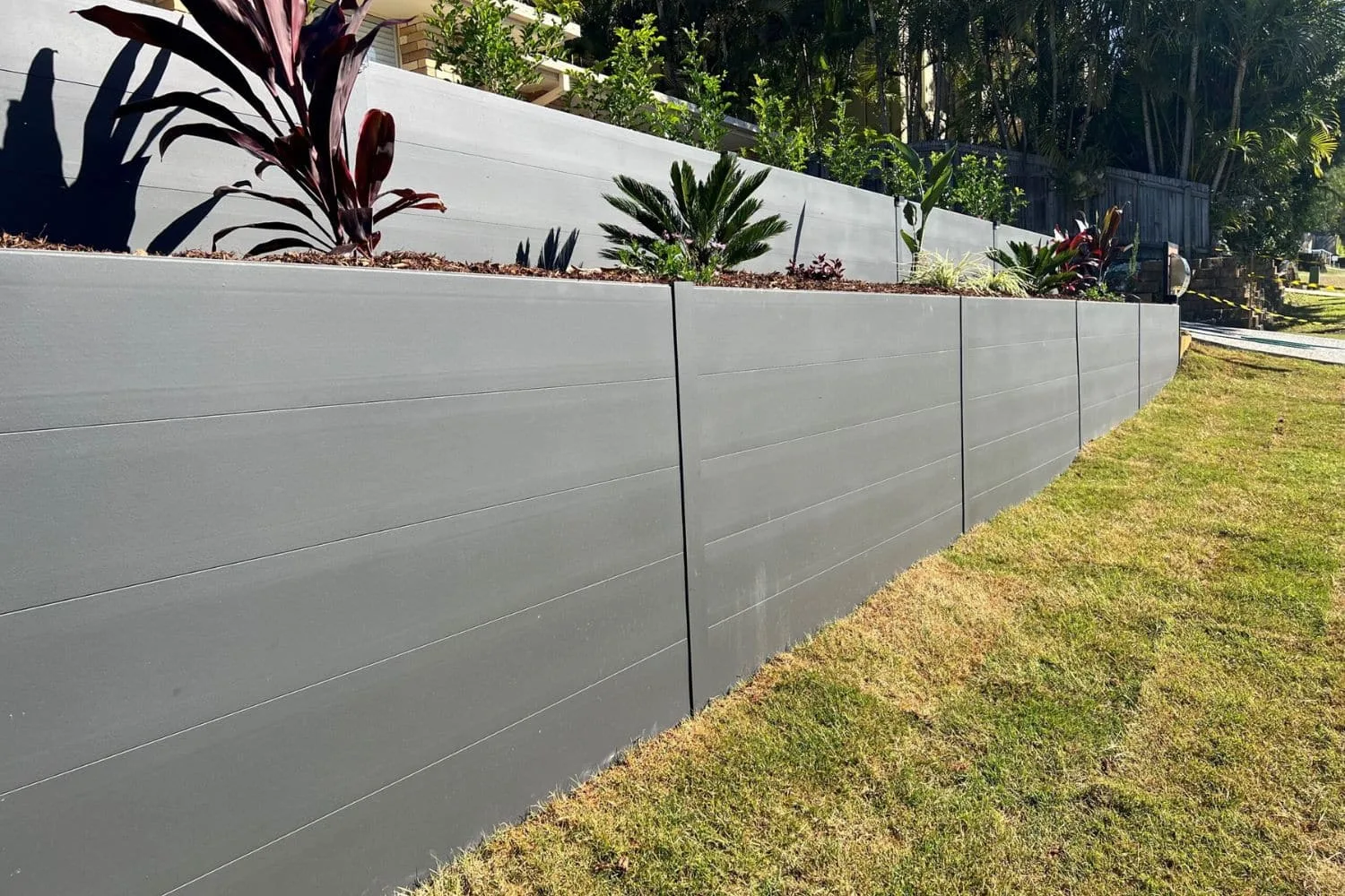Rendered concrete retaining wall with garden bed on top